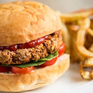 Chipotle, sriracha, ranch, bean patty with seasoning, cheese slice, tomato, pickles, onions, lettuce